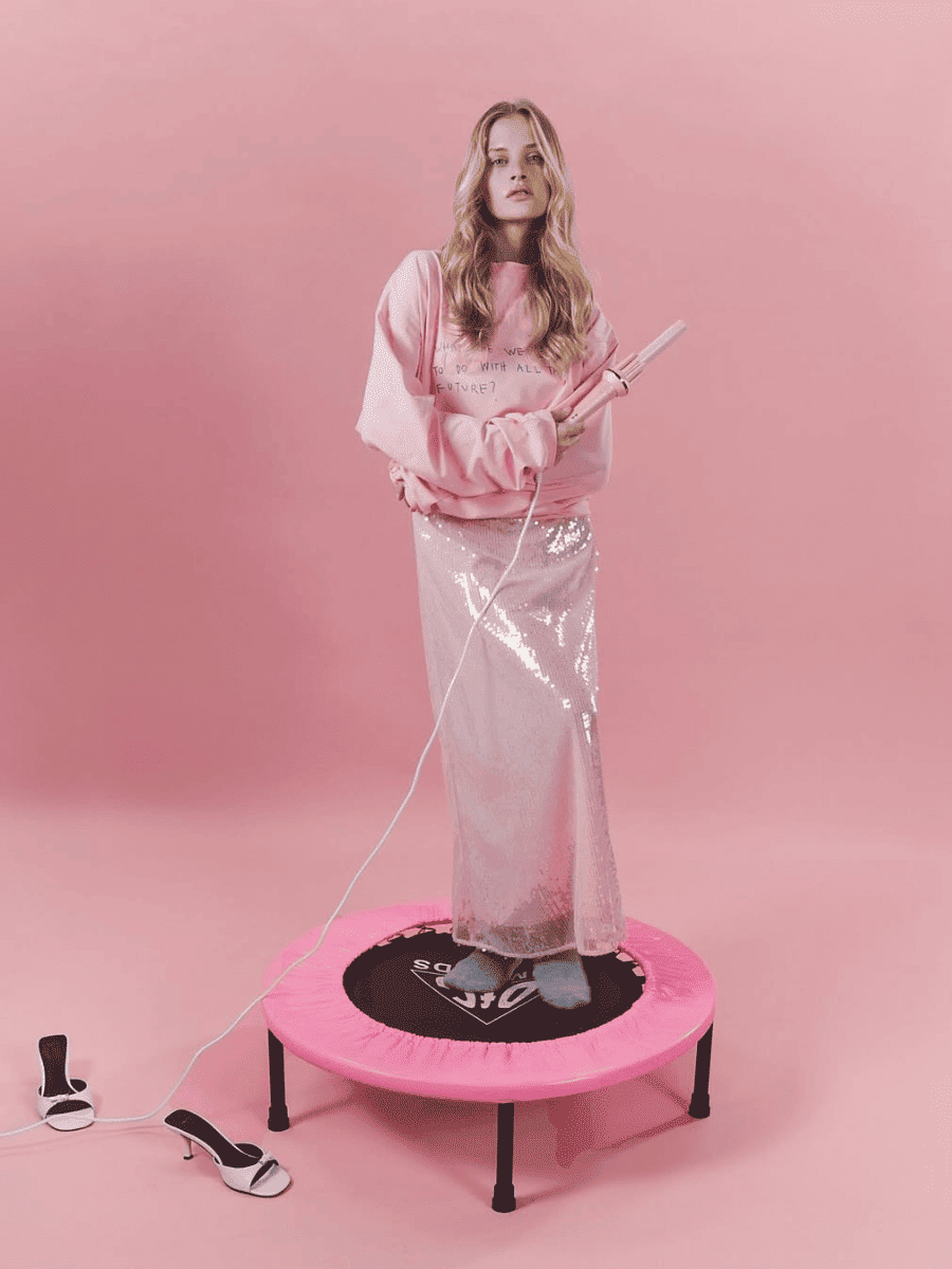 Woman on a pink trampoline with a pink background